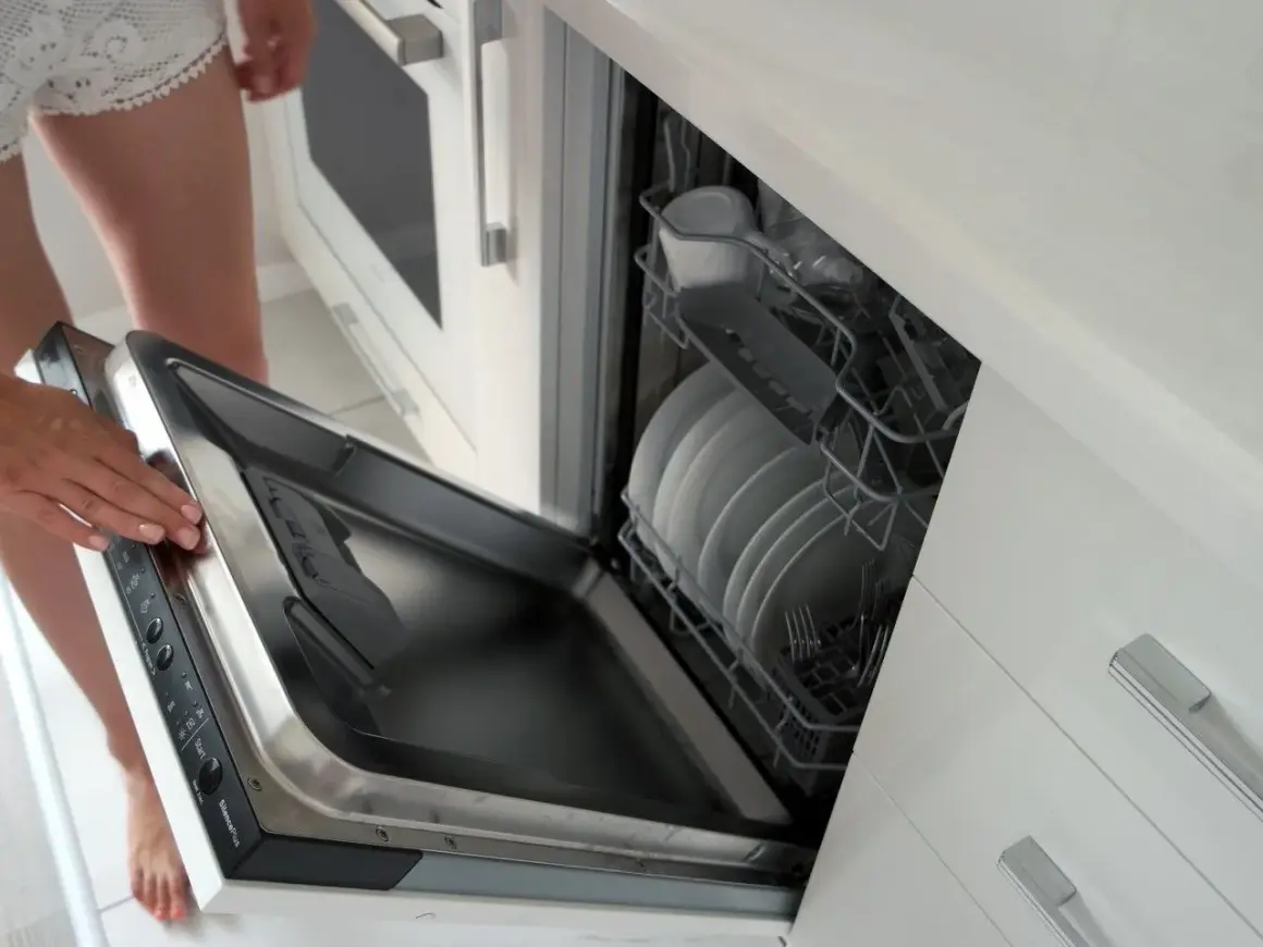Instrukcja: jak zamontować front do zmywarki Whirlpool. Otwarta zmywarka z koszami pełnymi naczyń.