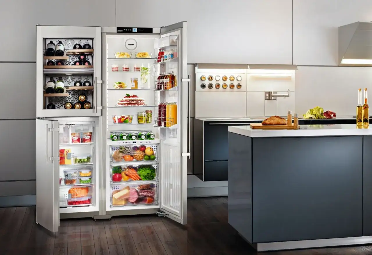 Nowoczesna lodówka 4 drzwiowa z kostkarką, pełna świeżych produktów i napojów. Winiarka z winami i zamrażarka uzupełniają ten elegancki sprzęt.